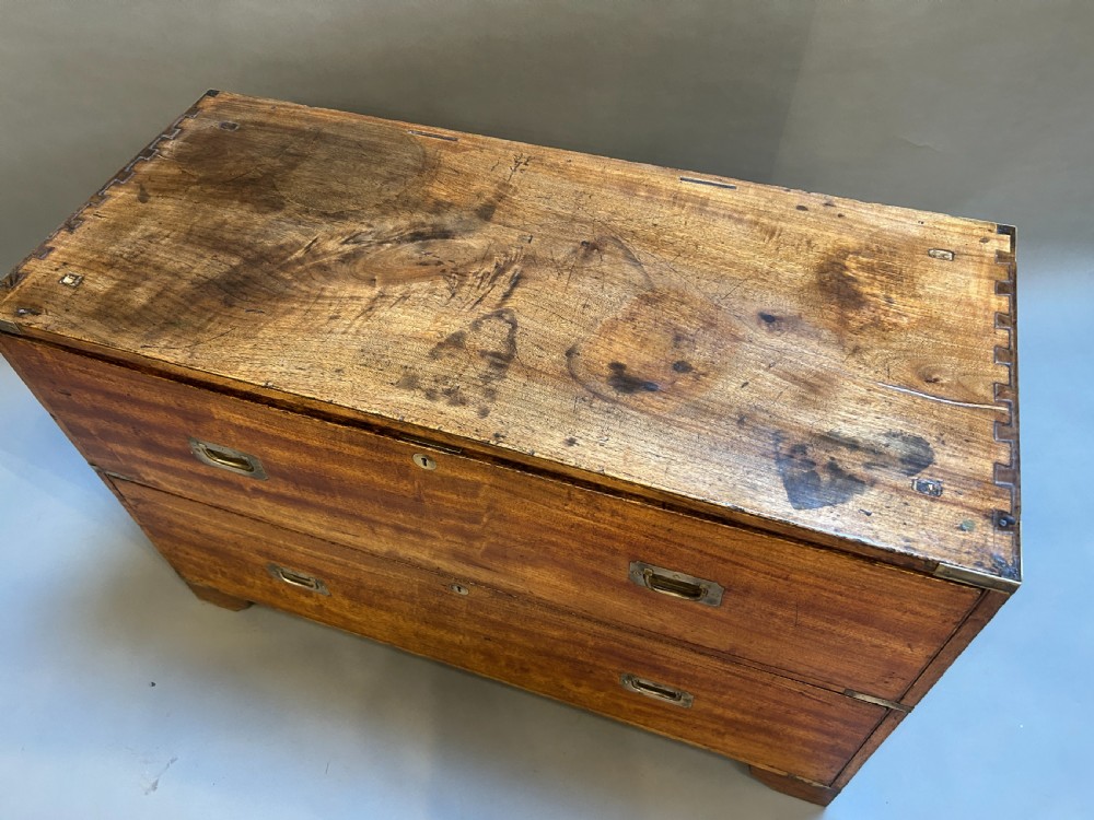 A nineteenth-century mahogany campaign chest featuring two wide drawers with flush brass handles, protective brass corner mounts, and side carrying handles. View IV