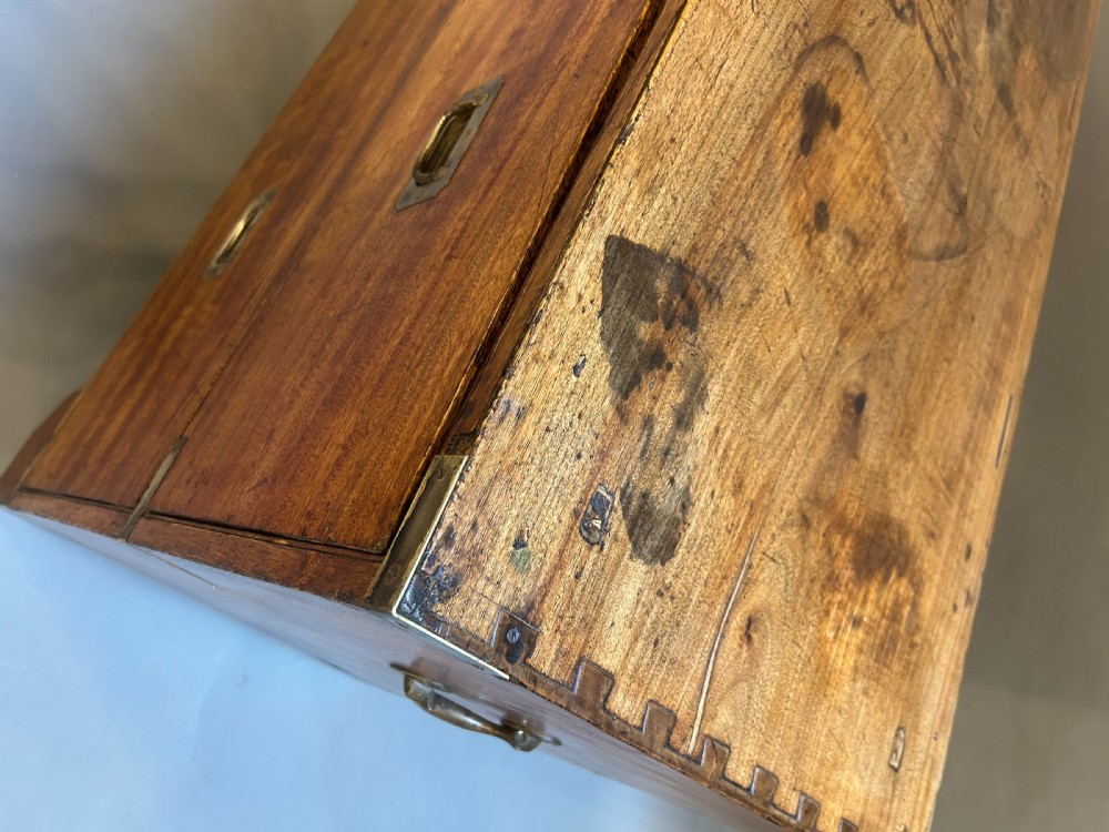 A nineteenth-century mahogany campaign chest featuring two wide drawers with flush brass handles, protective brass corner mounts, and side carrying handles. View V