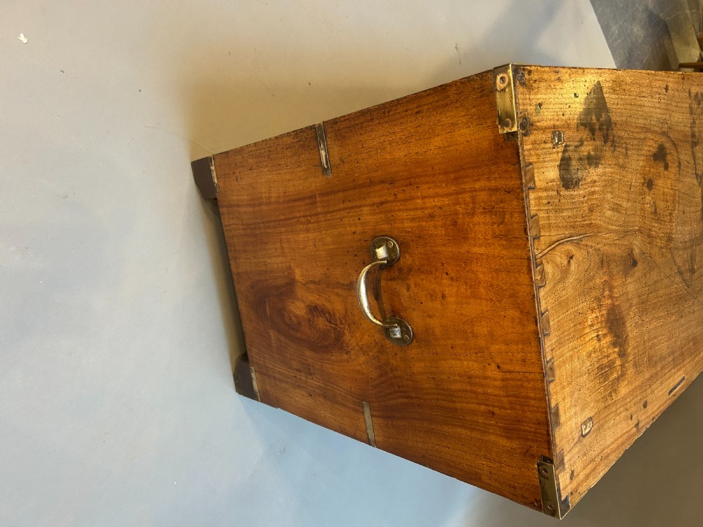 A nineteenth-century mahogany campaign chest featuring two wide drawers with flush brass handles, protective brass corner mounts, and side carrying handles. View VI