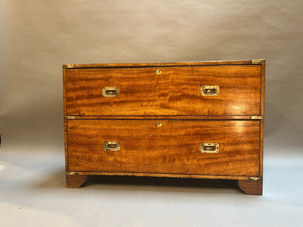 A nineteenth-century mahogany campaign chest featuring two wide drawers with flush brass handles, protective brass corner mounts, and side carrying handles. View VII