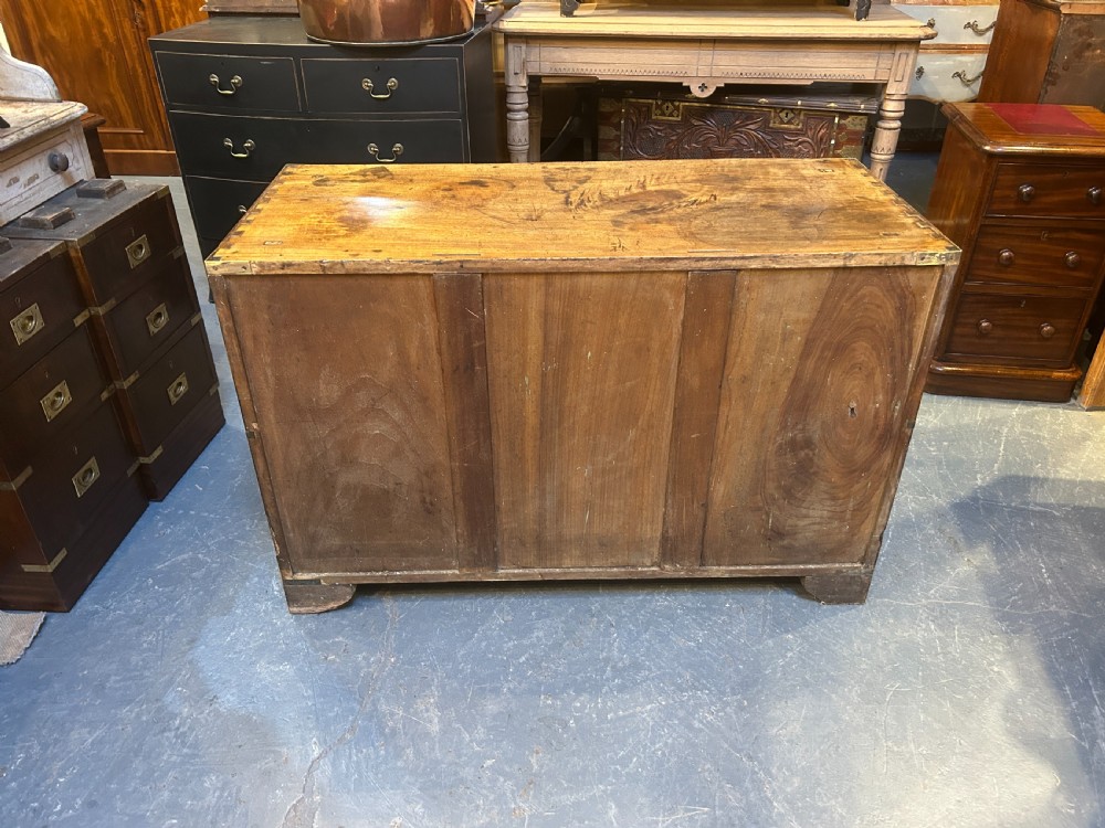 A nineteenth-century mahogany campaign chest featuring two wide drawers with flush brass handles, protective brass corner mounts, and side carrying handles. View XII