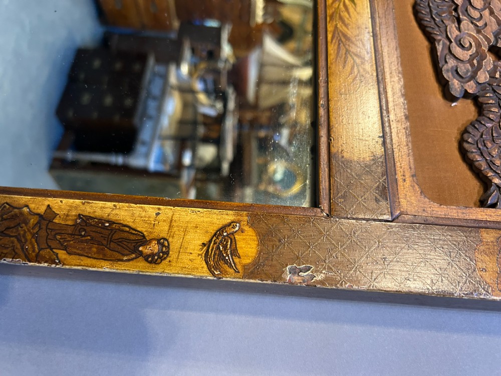 A tall, narrow timber wall mirror decorated with relief carvings of dragons and waves at the top and bottom, framed by gilt painted chinoiserie side borders. View IV