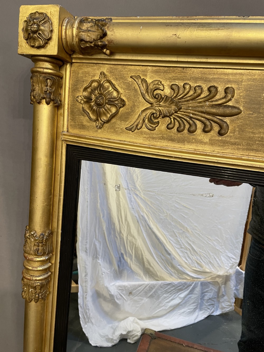 A large horizontal Regency gilt overmantel mirror featuring neoclassical side columns, a frieze with carved palmettes and rosettes, and an ebonised inner slip. View III