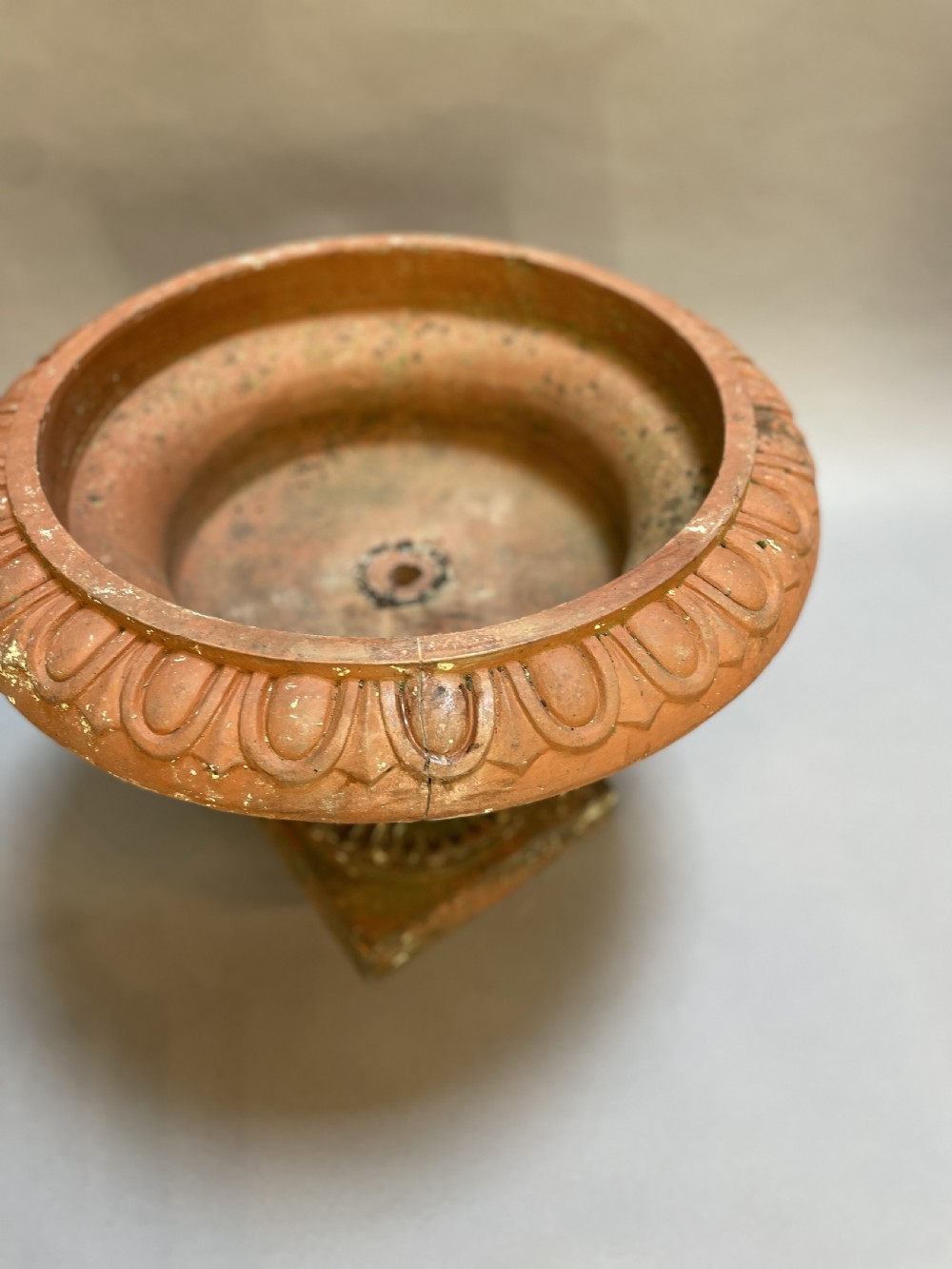A pair of weathered terracotta Campana garden urns featuring wide egg-and-dart rims, gadrooned lower bowls, fluted stems, and square bases. View VIII
