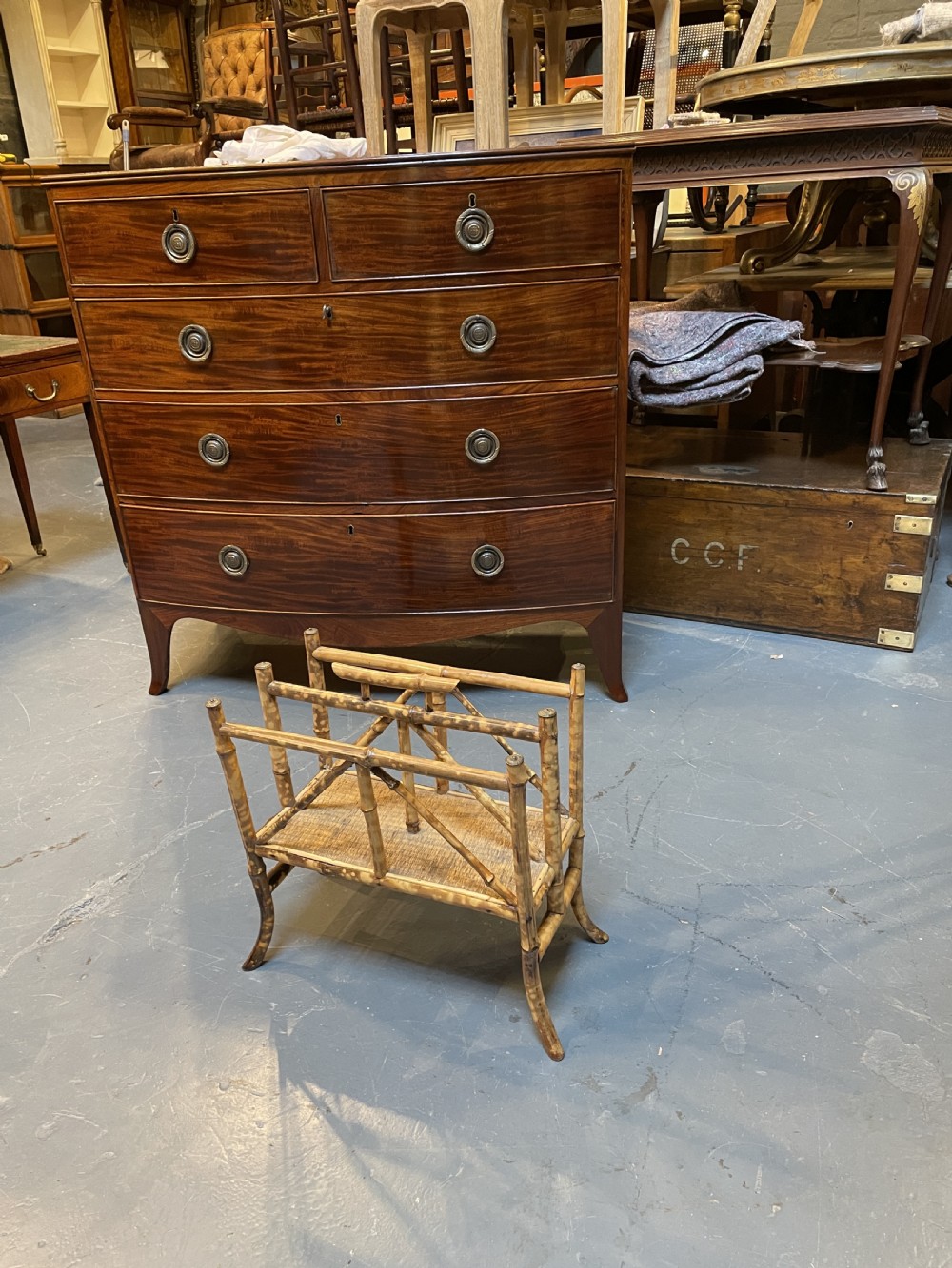 A late 19th-century bamboo canterbury rack featuring diagonal cross-bracing, a woven lower shelf, four partitioned sections, and metal capped finials. View VII