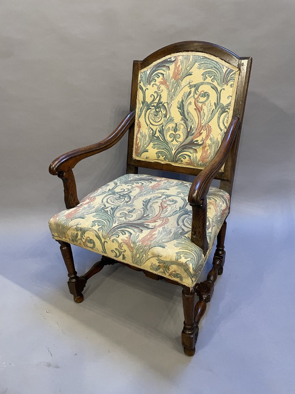 A 19th-century French fauteuil armchair with a carved dark wooden frame, open curved arms, turned stretchers, and leafy tapestry upholstery. View II