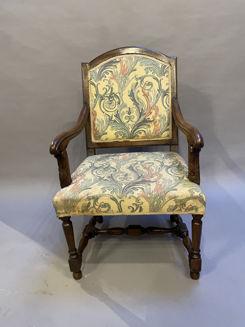 A 19th-century French fauteuil armchair with a carved dark wooden frame, open curved arms, turned stretchers, and leafy tapestry upholstery. View III