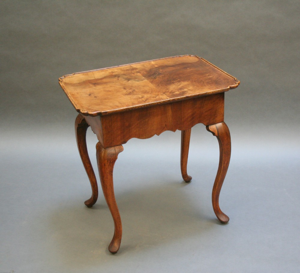 A George III style walnut lowboy side table featuring a single central drawer, shaped apron, and cabriole legs. View VI
