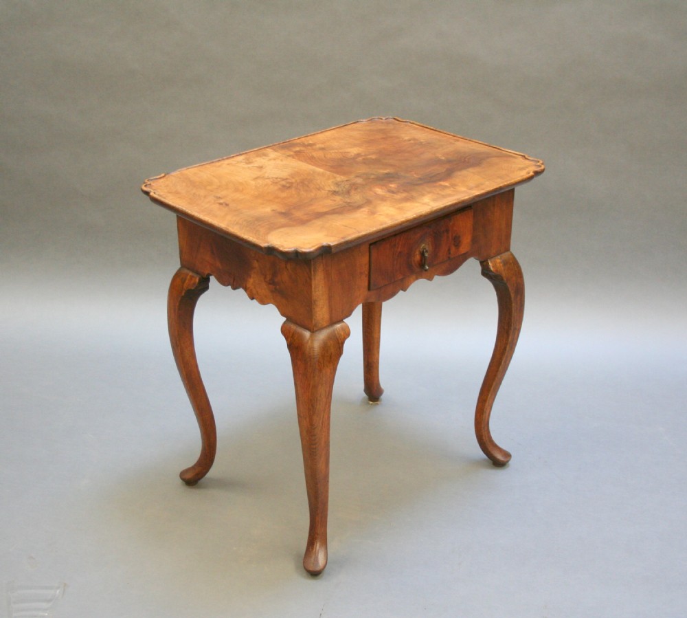 A George III style walnut lowboy side table featuring a single central drawer, shaped apron, and cabriole legs. View VII