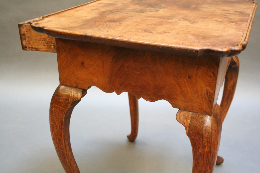 A George III style walnut lowboy side table featuring a single central drawer, shaped apron, and cabriole legs. View X