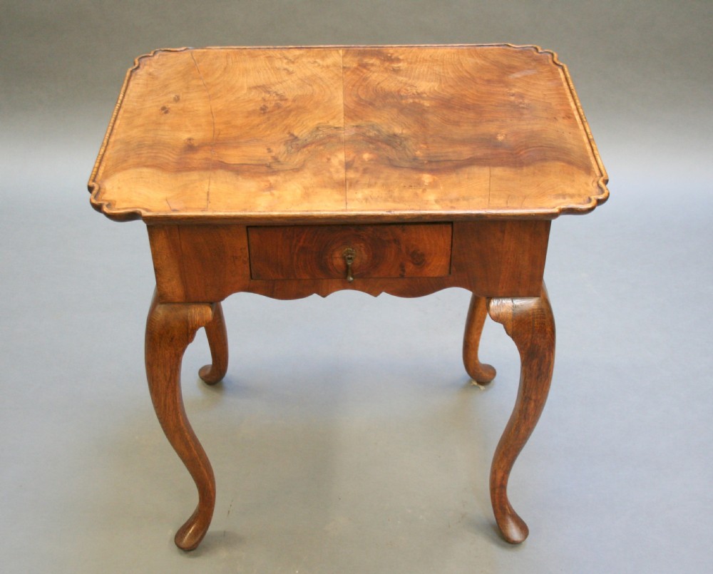 A George III style walnut lowboy side table featuring a single central drawer, shaped apron, and cabriole legs. View XII