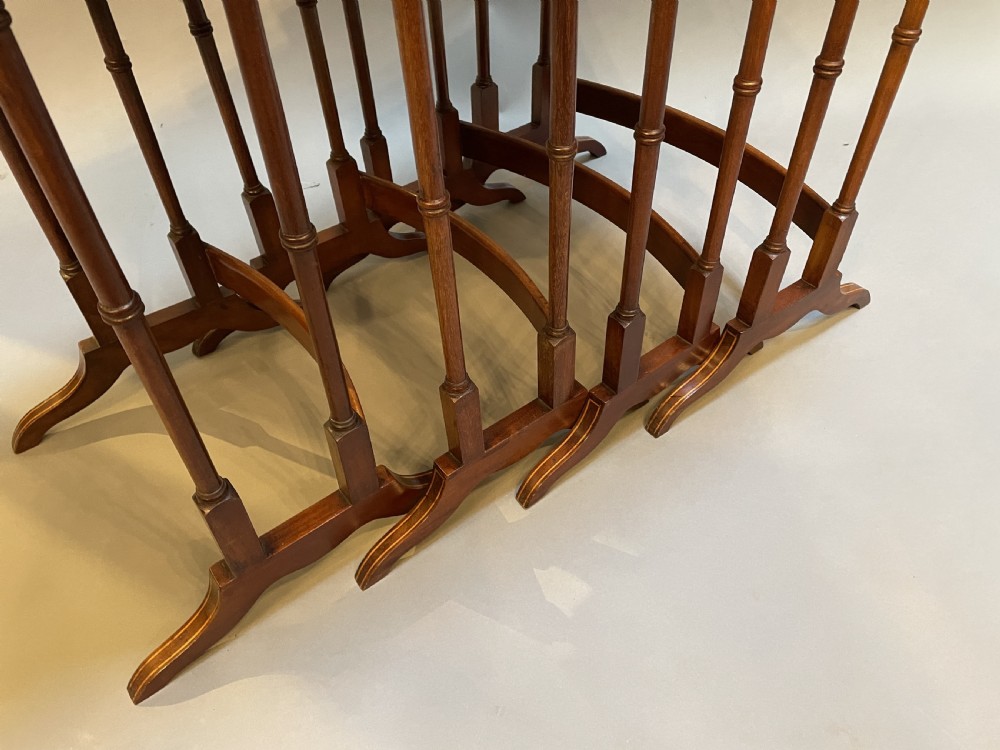 A set of four Edwardian mahogany nesting tables with turned legs, arched stretchers, and inlaid wood borders, arranged in a stepped cascade. View V