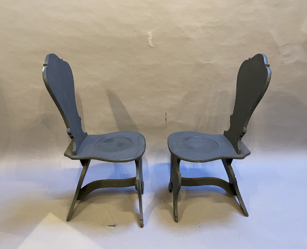 A pair of grey painted wooden Sgabello hall chairs featuring shaped cartouche backs and carved trestle supports. View III