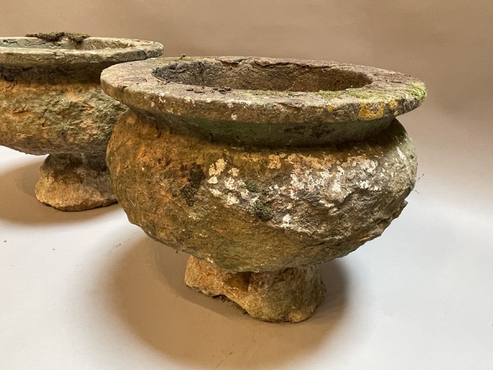 A pair of nineteenth-century carved soft stone garden urns featuring a rounded basin on a short pedestal base with a weathered, textured surface. View II