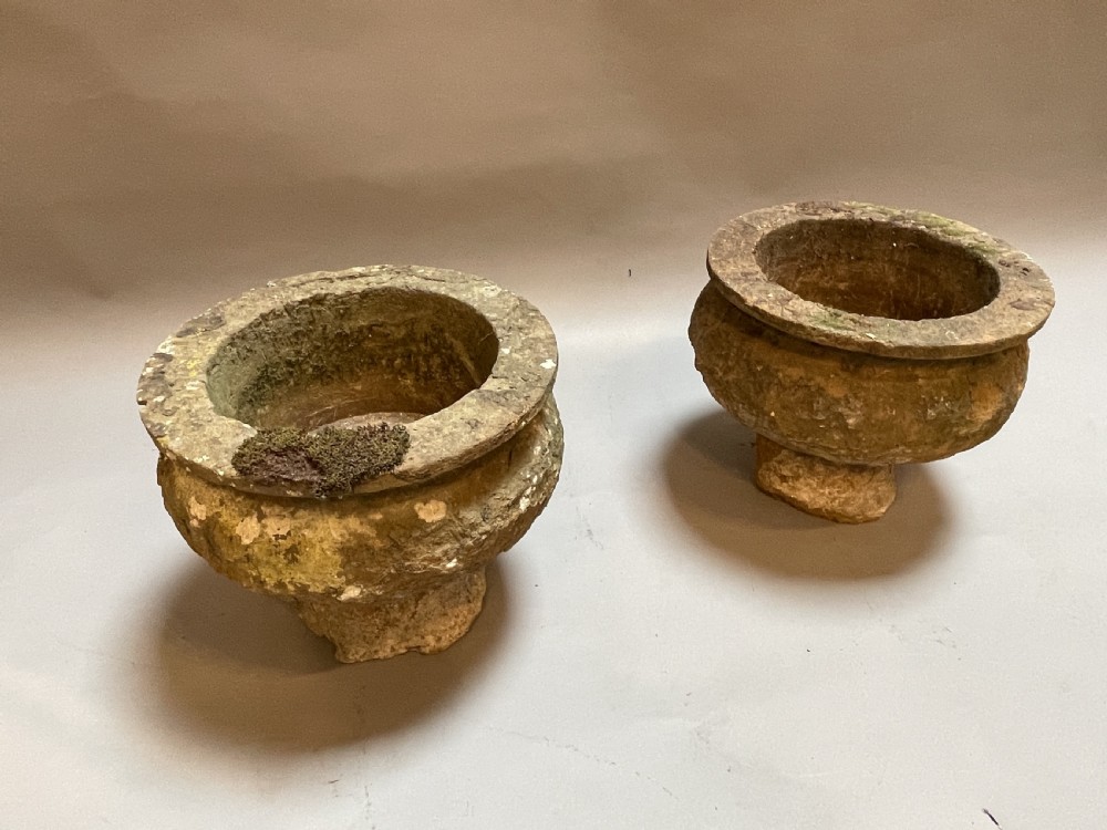 A pair of nineteenth-century carved soft stone garden urns featuring a rounded basin on a short pedestal base with a weathered, textured surface. View V