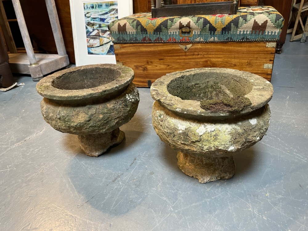 A pair of nineteenth-century carved soft stone garden urns featuring a rounded basin on a short pedestal base with a weathered, textured surface. View VI