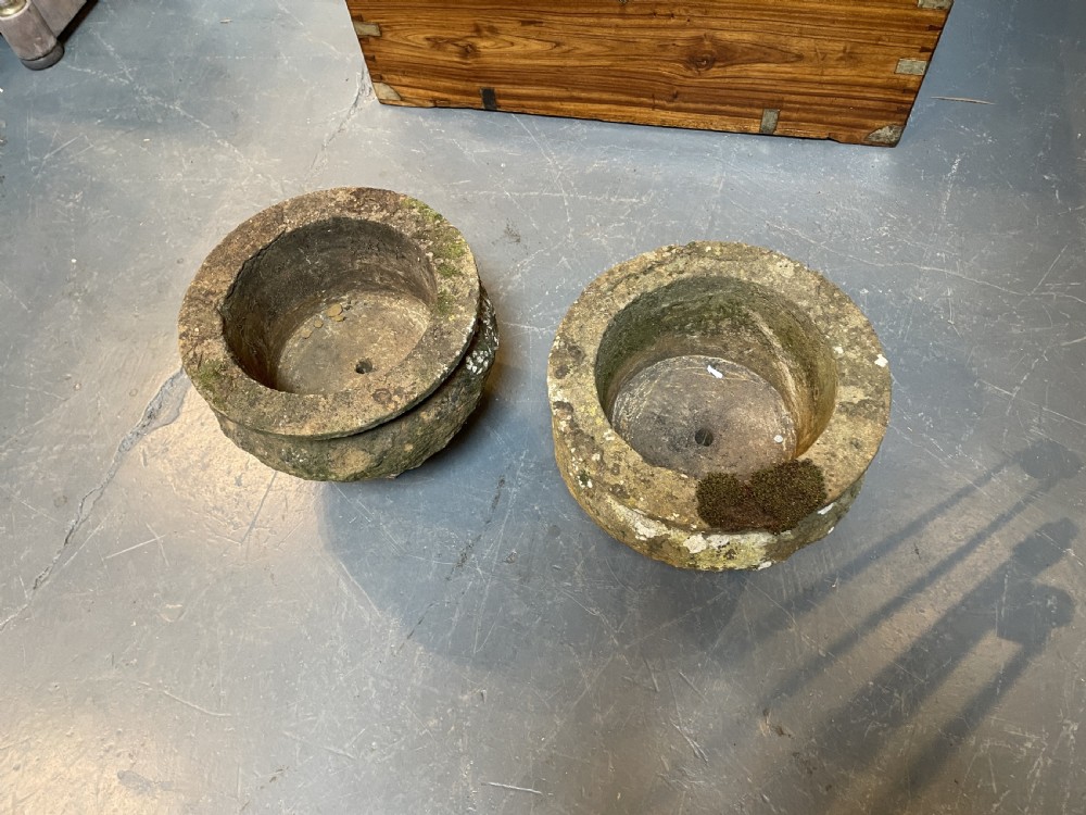 A pair of nineteenth-century carved soft stone garden urns featuring a rounded basin on a short pedestal base with a weathered, textured surface. View VII