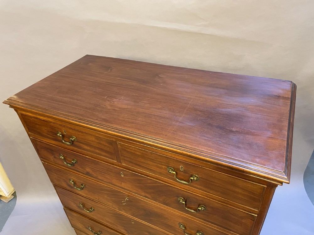 A George III mahogany tall chest of drawers featuring two short over five long graduated drawers with brass swan-neck handles and bracket feet. View VII