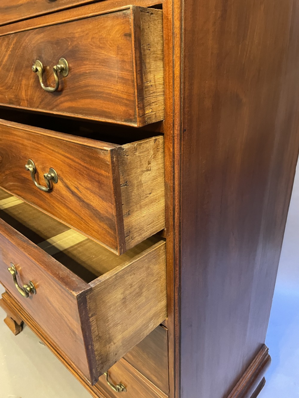 A George III mahogany tall chest of drawers featuring two short over five long graduated drawers with brass swan-neck handles and bracket feet. View IX