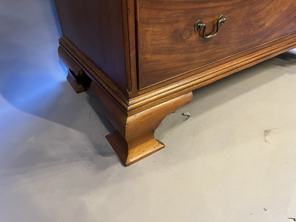 A George III mahogany tall chest of drawers featuring two short over five long graduated drawers with brass swan-neck handles and bracket feet. View X