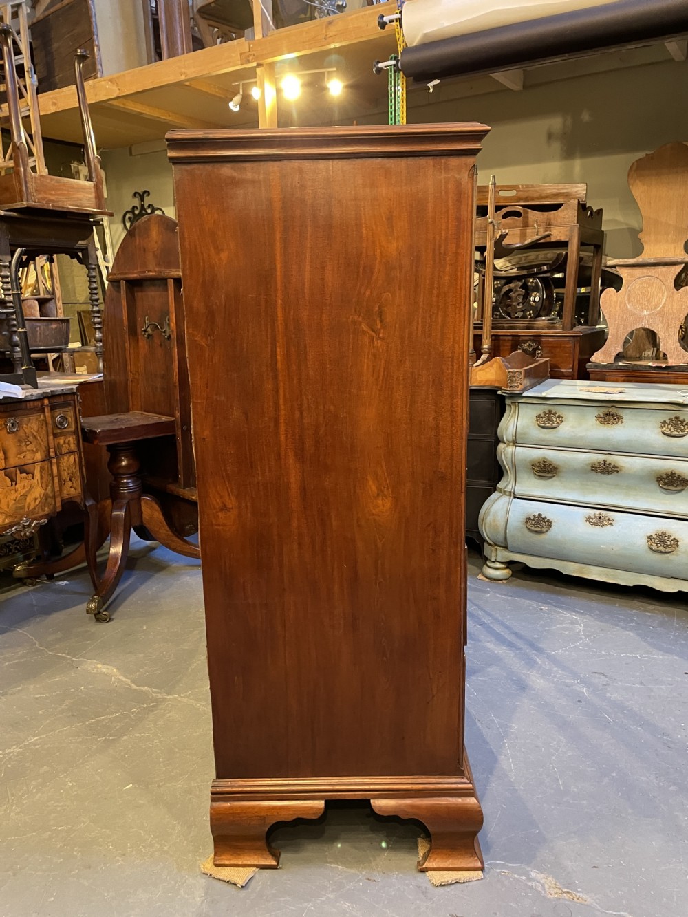 A George III mahogany tall chest of drawers featuring two short over five long graduated drawers with brass swan-neck handles and bracket feet. View XIII