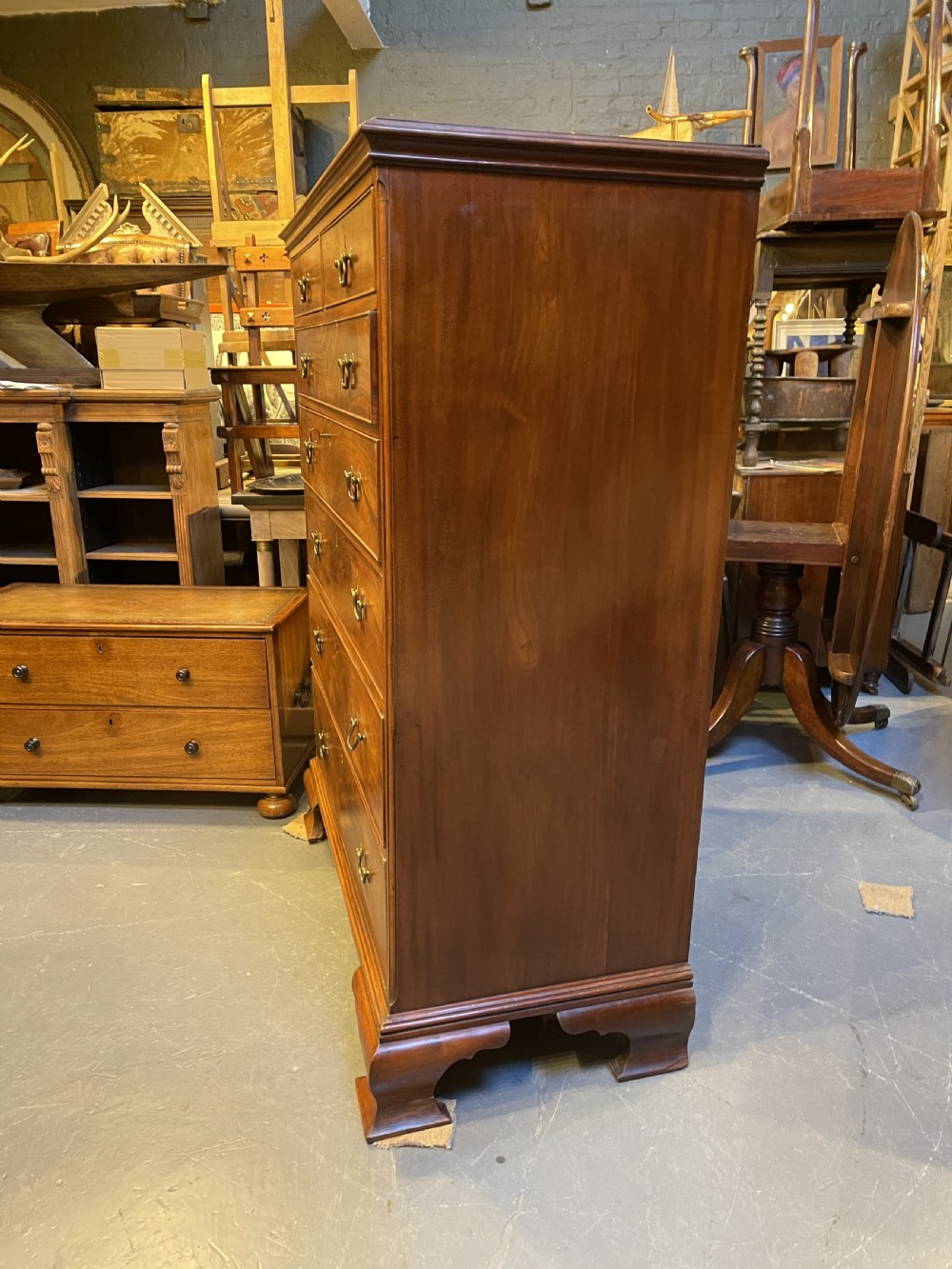 A George III mahogany tall chest of drawers featuring two short over five long graduated drawers with brass swan-neck handles and bracket feet. View XIV