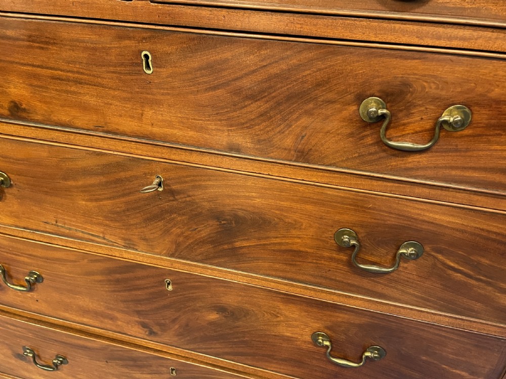 A George III mahogany tall chest of drawers featuring two short over five long graduated drawers with brass swan-neck handles and bracket feet. View XVI