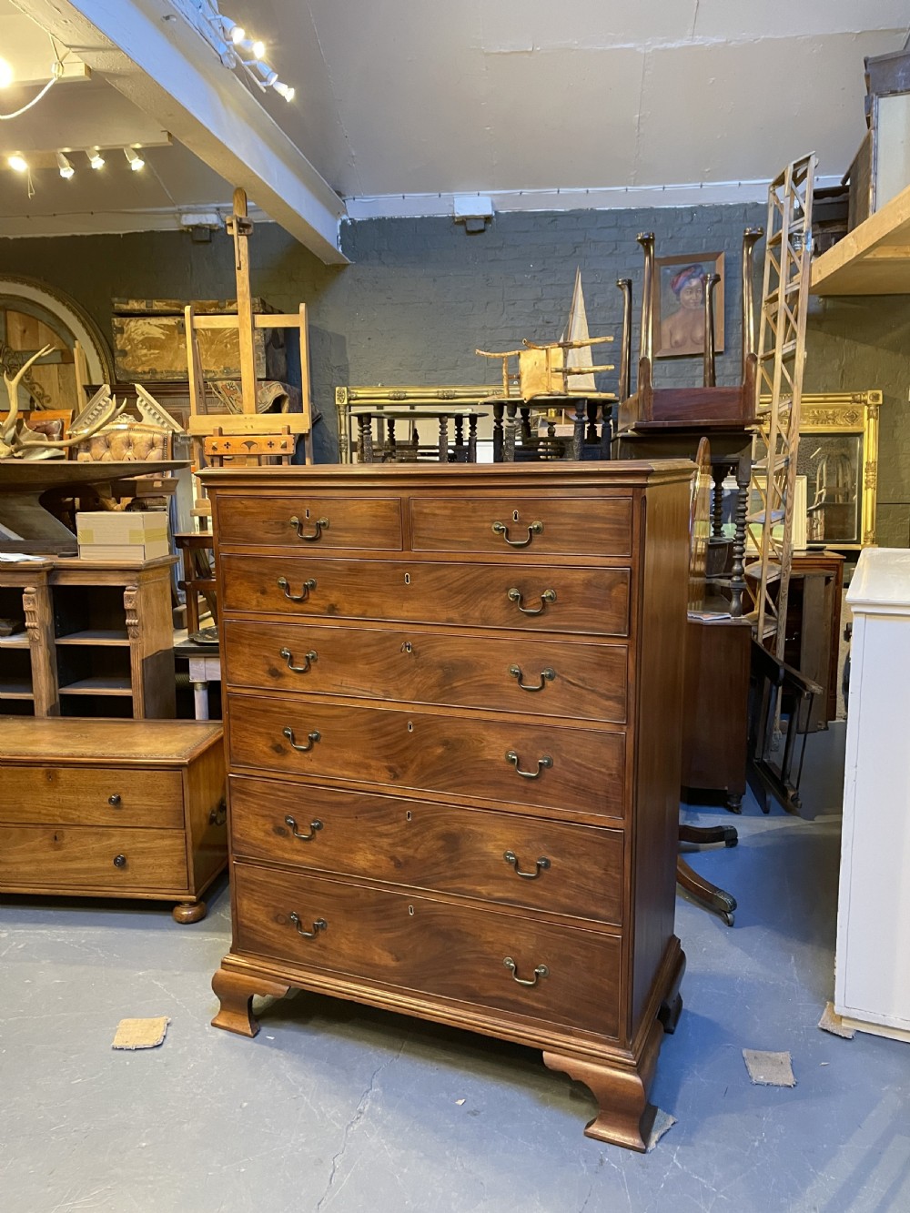 A George III mahogany tall chest of drawers featuring two short over five long graduated drawers with brass swan-neck handles and bracket feet. View XXI