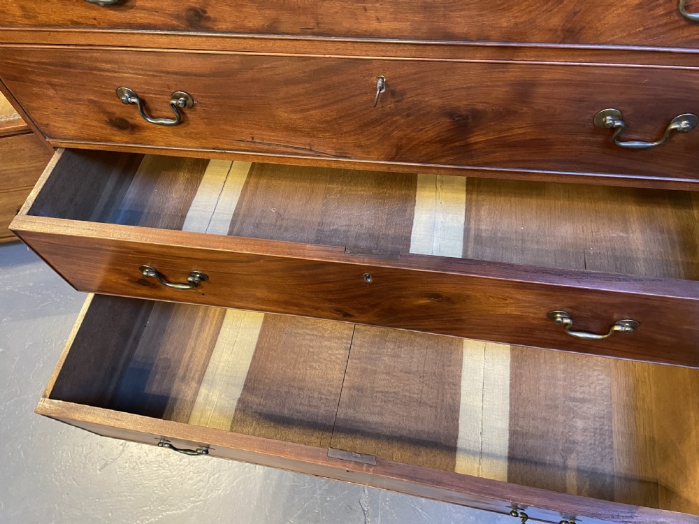 A George III mahogany tall chest of drawers featuring two short over five long graduated drawers with brass swan-neck handles and bracket feet. View XXIV