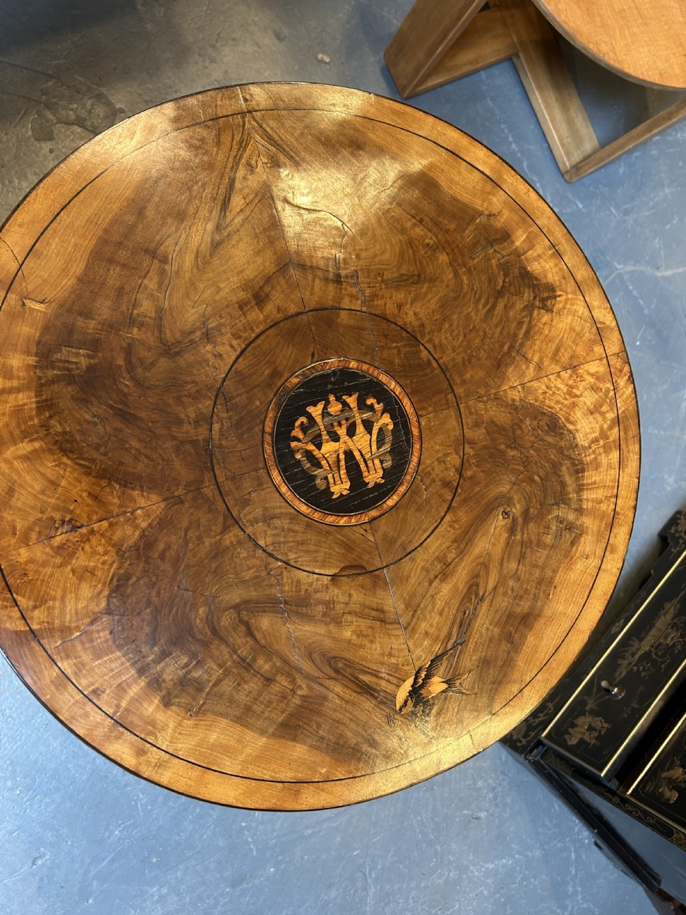 A 19th-century Italian circular occasional table made of warm brown burr walnut with a central marquetry motif, three bobbin-turned legs, and a lower tier shelf. View IV