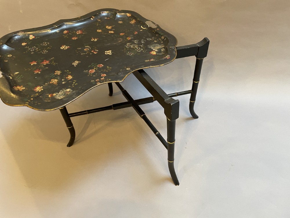 A Victorian black painted toleware tray table with hand-painted floral motifs, a scalloped edge, and faux bamboo legs. View III
