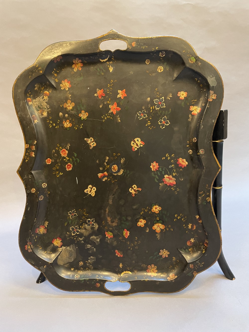 A Victorian black painted toleware tray table with hand-painted floral motifs, a scalloped edge, and faux bamboo legs. View IV