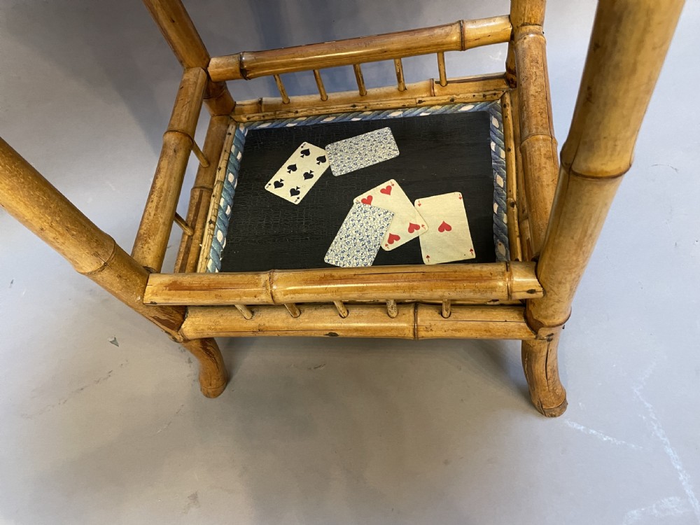 A late nineteenth-century Victorian bamboo occasional table featuring a two-tier structure with decoupage playing cards under varnish on the surfaces. View III