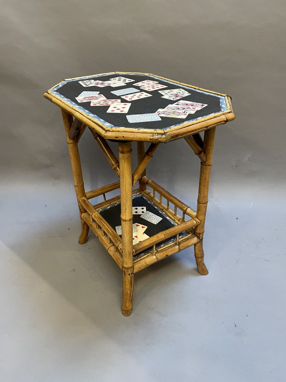 A late nineteenth-century Victorian bamboo occasional table featuring a two-tier structure with decoupage playing cards under varnish on the surfaces. View IV