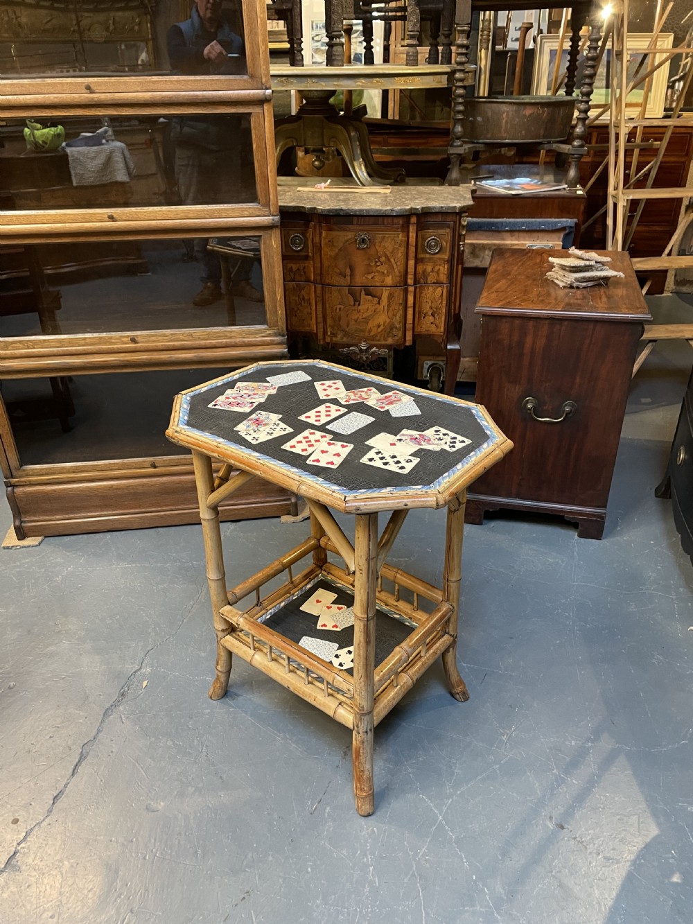 A late nineteenth-century Victorian bamboo occasional table featuring a two-tier structure with decoupage playing cards under varnish on the surfaces. View VI
