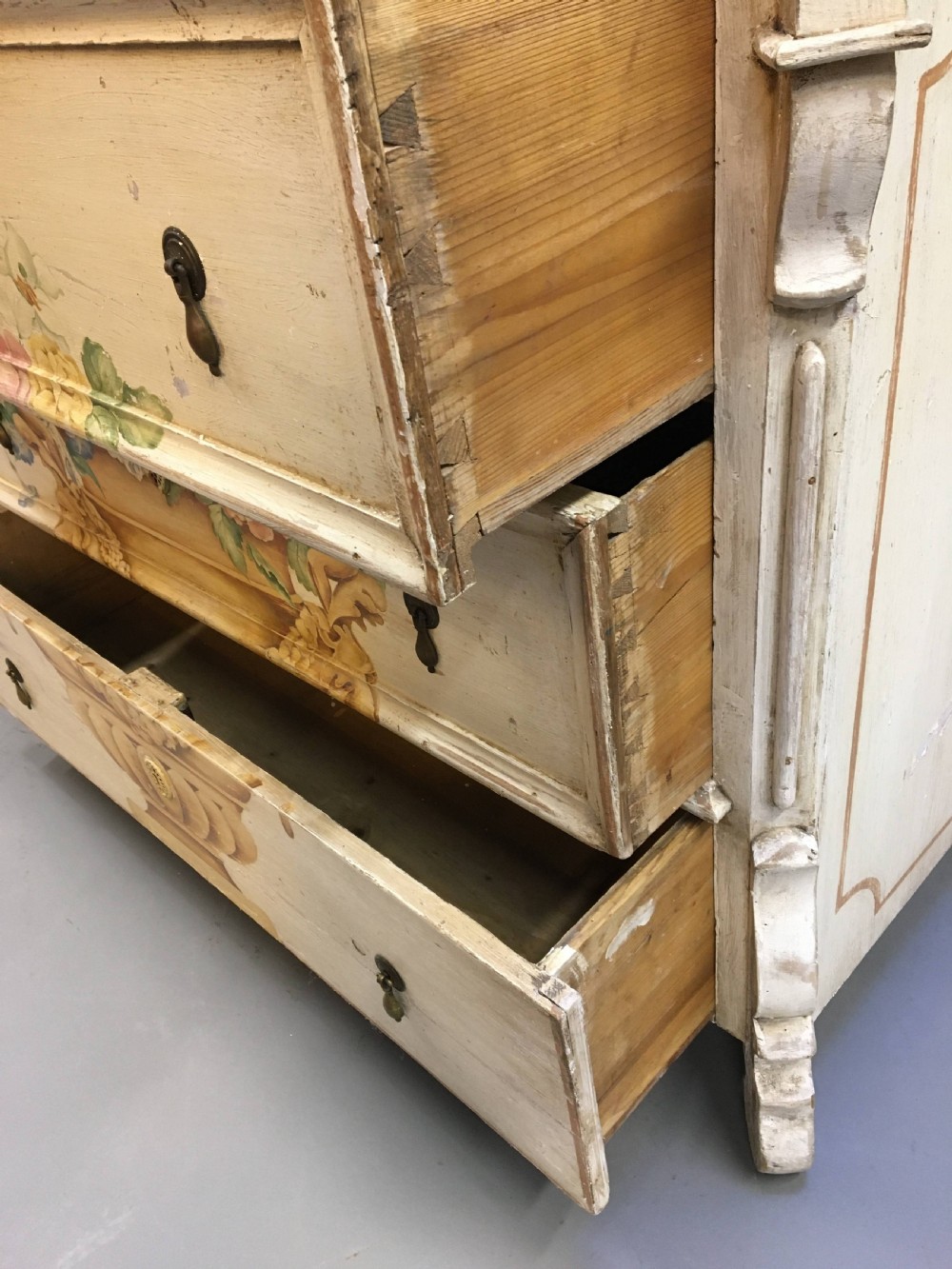 A 19th-century cream painted chest of drawers featuring three long drawers decorated with a central hand-painted motif of a floral urn. View IV