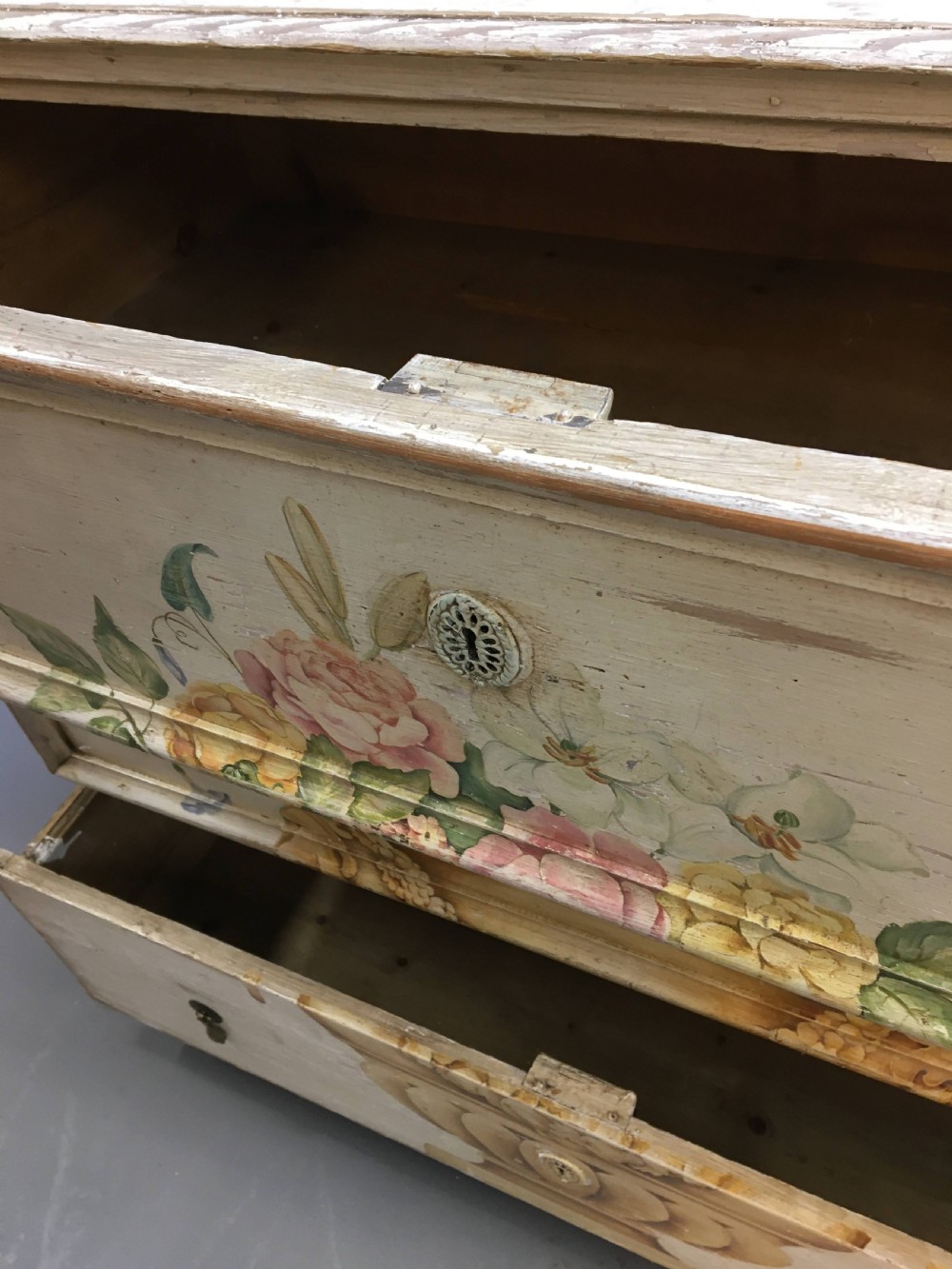A 19th-century cream painted chest of drawers featuring three long drawers decorated with a central hand-painted motif of a floral urn. View V