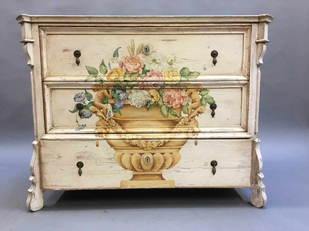 A 19th-century cream painted chest of drawers featuring three long drawers decorated with a central hand-painted motif of a floral urn. View VI