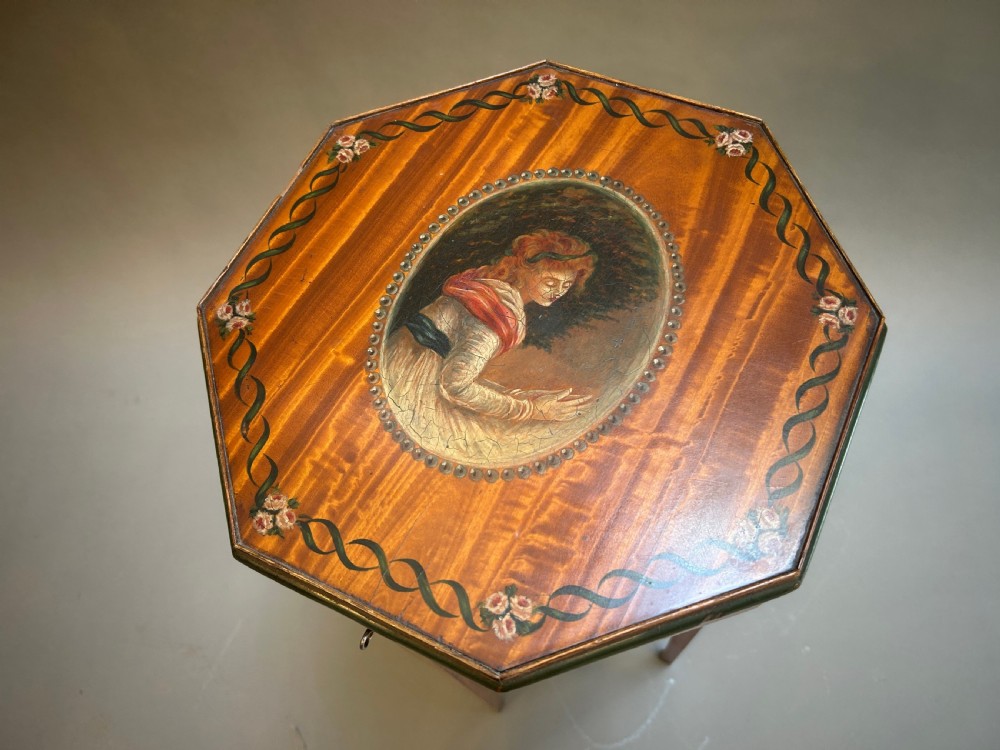 A tall octagonal Sheraton Revival side table featuring hand-painted floral garlands, a central painted vignette on the top, slender tapered legs, and a cross-stretcher. View II