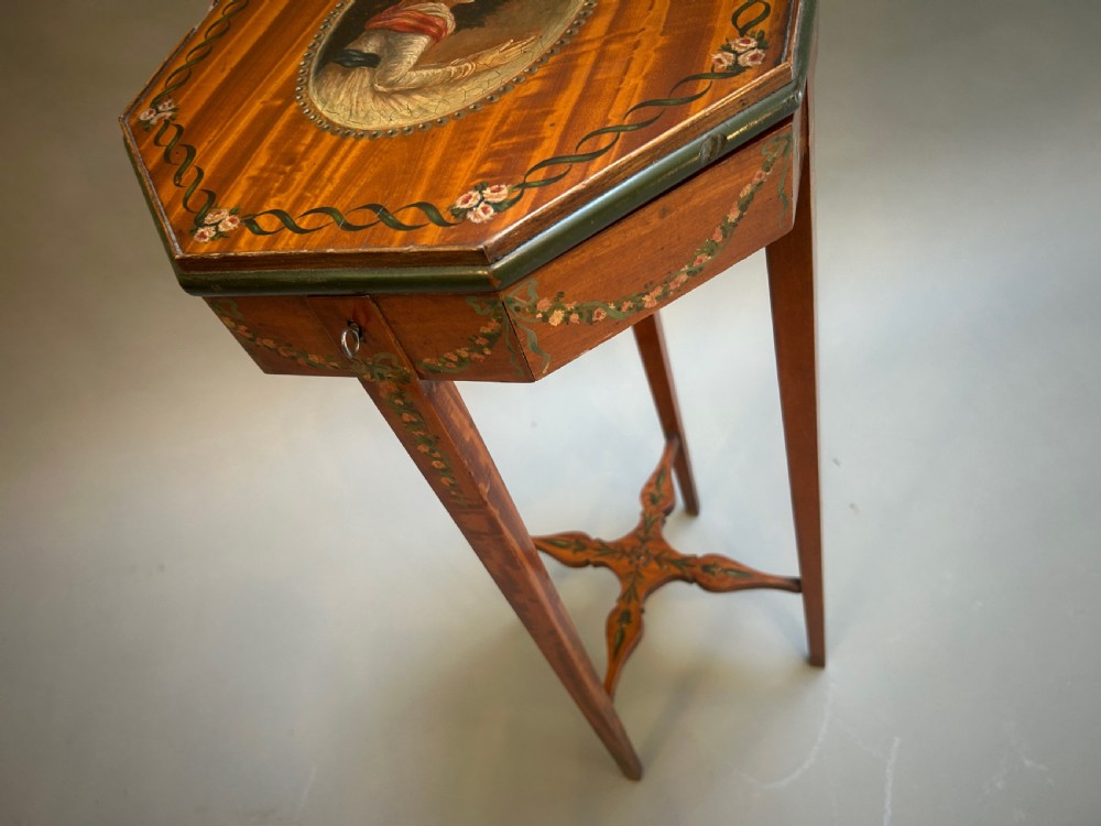 A tall octagonal Sheraton Revival side table featuring hand-painted floral garlands, a central painted vignette on the top, slender tapered legs, and a cross-stretcher. View III