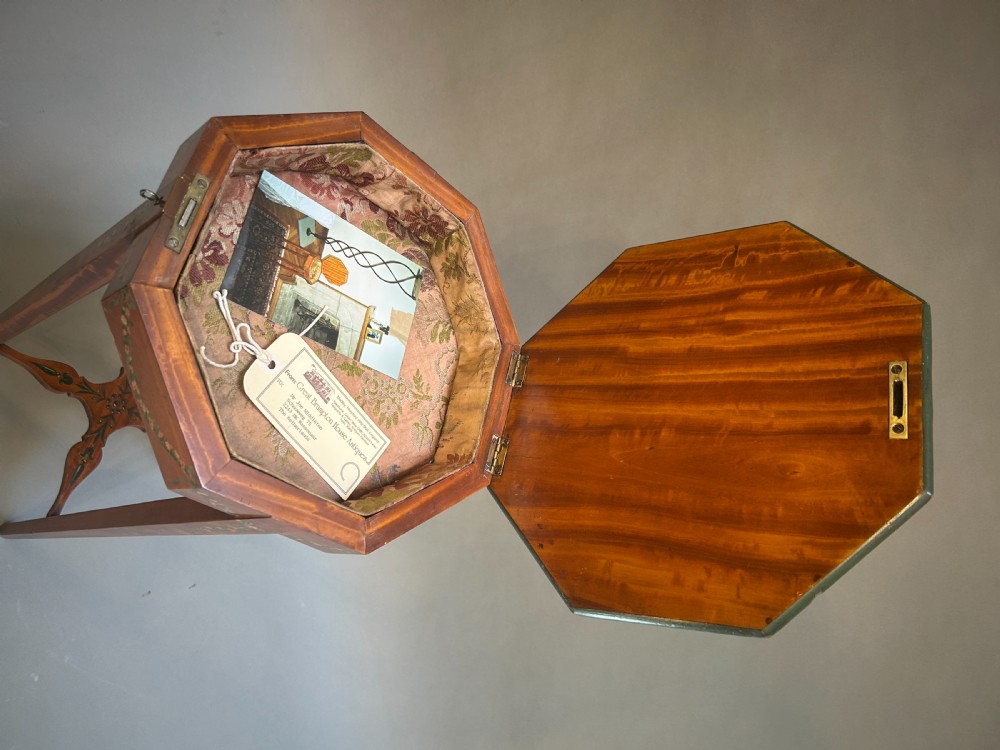 A tall octagonal Sheraton Revival side table featuring hand-painted floral garlands, a central painted vignette on the top, slender tapered legs, and a cross-stretcher. View VI