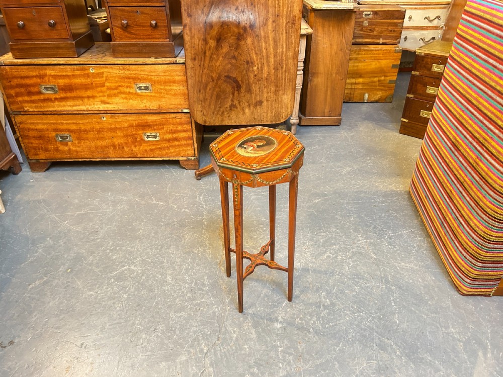 A tall octagonal Sheraton Revival side table featuring hand-painted floral garlands, a central painted vignette on the top, slender tapered legs, and a cross-stretcher. View VII
