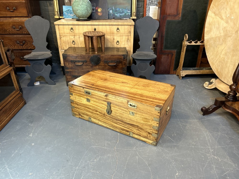 An antique rectangular camphor wood campaign trunk with flush metal handles, corner brackets, exposed dovetail joinery, and a central latch. View IX