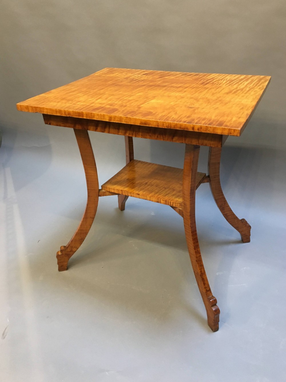 An Art Deco golden Karelian birch side table featuring a square top, lower tier shelf, and flared outward curved legs. View IX