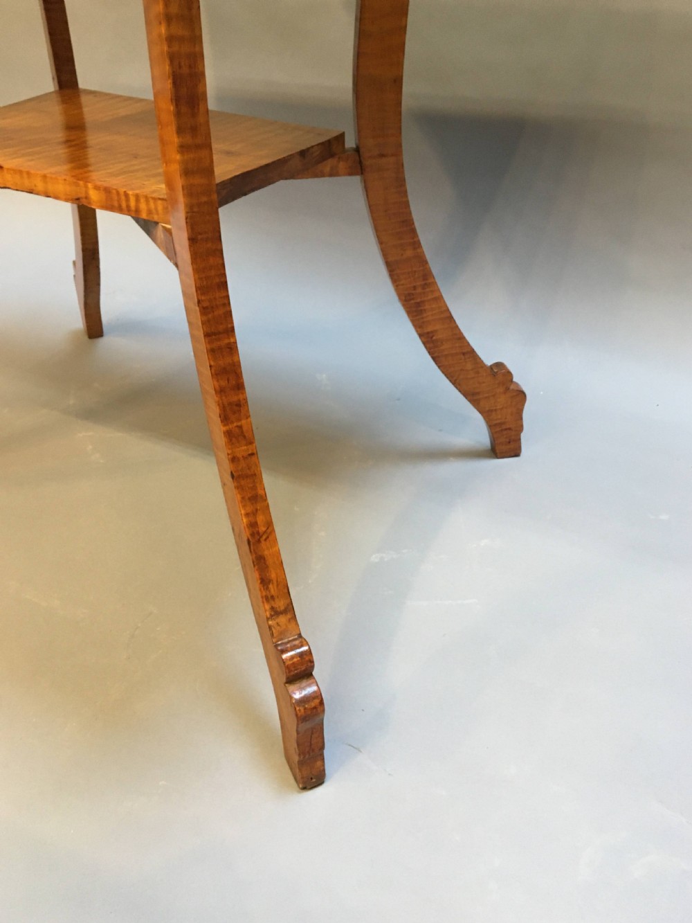 An Art Deco golden Karelian birch side table featuring a square top, lower tier shelf, and flared outward curved legs. View X