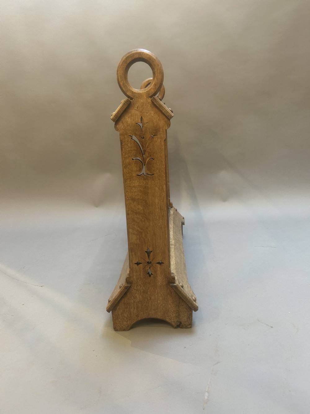 An antique oak umbrella and stick stand featuring a scalloped upper rail, carved ring handles, inlaid side uprights, and a metal drip tray at the base. View VIII