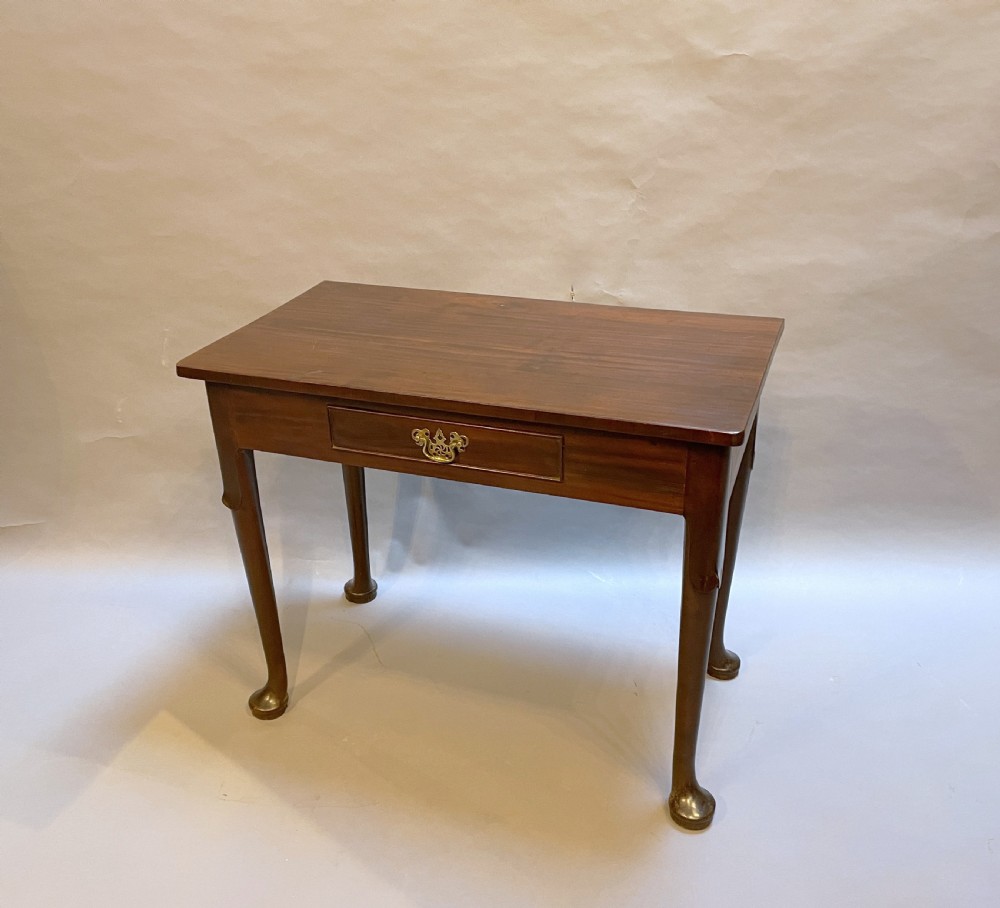 A George III mahogany side table featuring a single drawer with a brass handle and cabriole legs terminating in pad feet.