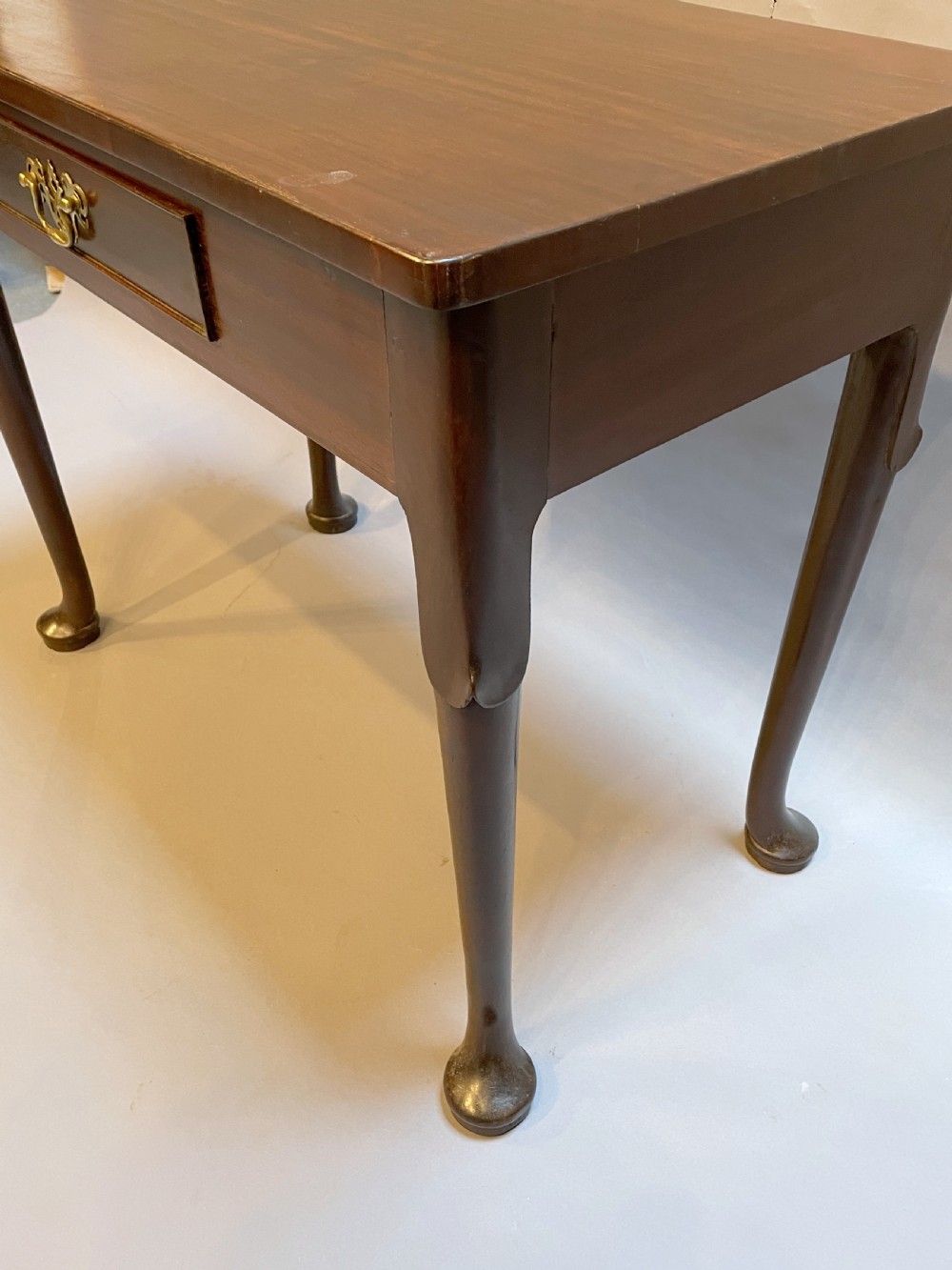 A George III mahogany side table featuring a single drawer with a brass handle and cabriole legs terminating in pad feet. View IV