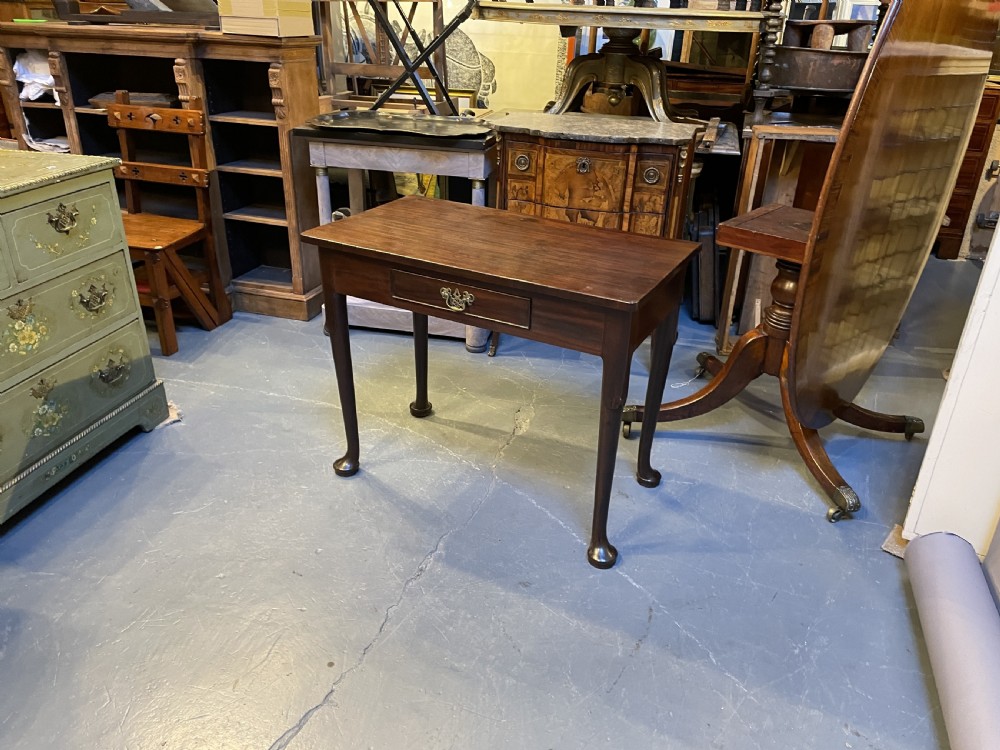 A George III mahogany side table featuring a single drawer with a brass handle and cabriole legs terminating in pad feet. View VII