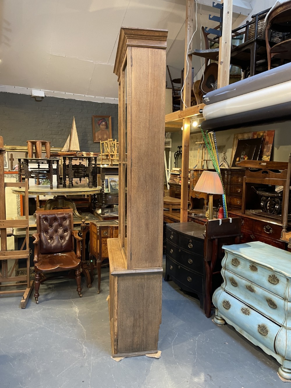A tall Victorian light oak two-part bookcase with two upper glazed doors revealing adjustable shelves and a two-door cupboard base. View XI